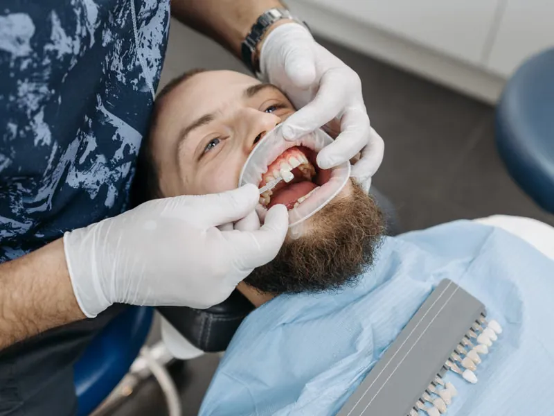 Dentist examining patient teeth during dental crown consultation at Deekshu Dental Bangalore