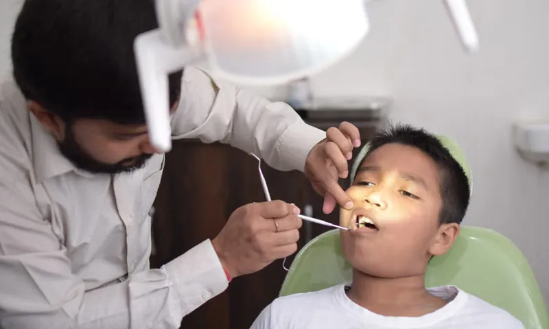 Dentist examining young child's teeth and jaw alignment during early orthodontic consultation at Sarjapura clinic