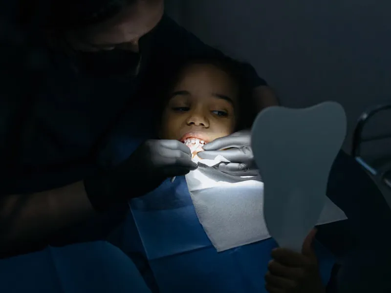 Friendly paediatric dentist in a warm, comfortable consultation with a young child at Deekshu Dental Implant Center Sarjapura Bangalore